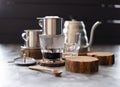 Vietnamese black drip coffee. Traditional Vietnamese coffee maker phin and goose neck kettle on wood slabs on dark background