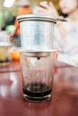 Vietnamese coffee in glass cups, traditional metal coffee maker phin. Black drip coffee as famous in Vietnam