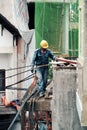 Vietnamese electricity worker climb high on house roof to repair electricity network