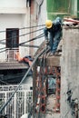 Vietnamese electricity worker climb high on house roof to repair electricity network