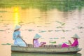 Vietnamese female group on a lotus wooden boat Asian women sit on a wooden boat to collect lotus flowers. Three beautiful women Royalty Free Stock Photo