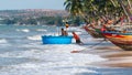 Vietnamese fishermen are pushing their fishing coracle out to the sea for their daily duty at Fisherman Village, Mui Ne, Vietnam