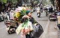 A Vietnamese flower seller walks in selling flowers in Hanoi, Vietnam.