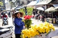 A Vietnamese flower seller walks in selling flowers in Hanoi, Vietnam.