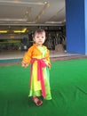 A lovely baby girl is playing in the street with a Vietnamese traditional four-part dress