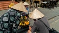 Vietnamese fruit sellers wearing a cone hat