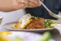 Vietnamese girl eating Com tam - a Vietnamese broken rice with pickles steak grilled pork ribs cucumber onion oil sweet chilies Royalty Free Stock Photo