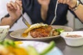 Vietnamese girl eating Com tam - a Vietnamese broken rice with pickles steak grilled pork ribs cucumber onion oil sweet chilies Royalty Free Stock Photo