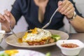 Vietnamese girl eating Com tam - a Vietnamese broken rice with pickles steak grilled pork ribs cucumber onion oil sweet chilies Royalty Free Stock Photo