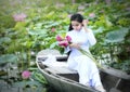 Vietnamese girl in traditional long dress or Ao Dai inside boat