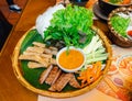 Vietnamese grilled meat or meatballs wrap set with vegetables and sweet sauce Nham Neung on table