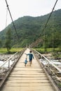 Vietnamese Hmong ethnic minority boy walking on old wooden bridge with his bicycle Royalty Free Stock Photo