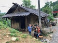 Vietnamese lady with two boys eating rice in front of her house