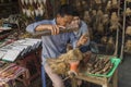 A Vietnamese man in ancient Hoian town carving from wood handmade toys and souvenirs in street market workshop.
