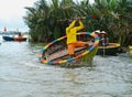 A Vietnamese man is dancing on colorful basket boat