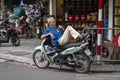 Vietnamese man rest on motorbike taxi on street in old town Hanoi , Vietnam