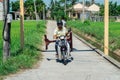 Vietnamese man transporting a table on a motorscooter