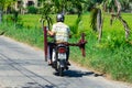 Vietnamese man transporting a table on a motorscooter