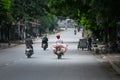 Vietnamese man transports piglets on a motorbike at a market