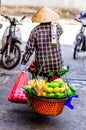 Vietnamese market trader balance food in Hanoi