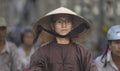 Vietnamese monk wears a specific Vietnamese hat in the street traffic of Hue city.