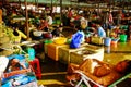 Vietnamese old woman is relaxing on the market between other sellers Royalty Free Stock Photo