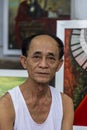 Vietnamese painter showing his paintings in the street. Hoi An, Vietnam. December 2, 2018