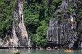 Vietnamese people and foreign travelers rowing paddle canoe boat travel visit cave and respect small shrine in Halong lake or Ha