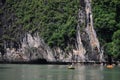 Vietnamese people and foreign travelers rowing paddle canoe boat travel visit cave and respect small shrine in Halong lake or Ha