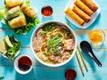 Vietnamese pho bo soup with appetizers on table and drizzled with sriracha sauce Royalty Free Stock Photo