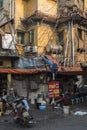 Vietnamese residents enjoy a quiet moment on the street by an old yellow building in Hanoi , Vietnam