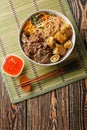 Vietnamese salad of beef and soy sauce, with crispy spring rolls and rice noodles, fresh herbs, vegetables closeup. Vertical top Royalty Free Stock Photo