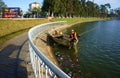 Vietnamese sanitation worker pick up rubbish from lake