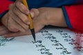 Vietnamese scholar writes calligraphy at lunar new year. Calligraphy festival is a popular tradition during Tet holiday. Text in p