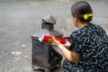 Vietnamese senior woman burning Joss money on Hanoi street. The act of burning these papers is believed to send that amount of
