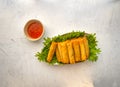 Vietnamese spring rolls in lettuce bed platter on white stone table, close up, copy space Royalty Free Stock Photo