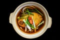 Vietnamese stewed sapa fish in bouillon isolated on black bacground top view