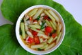 Vietnamese vegan food for lunch meal, tomato soup bowl cook with ripe tamarind, colocasia gigantea and basil leaf Royalty Free Stock Photo