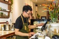 Vietnamese waiter working in counter with cashier machine in a cafe
