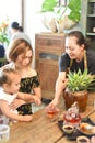 Vietnamese waitress serves hot tea for mother with daughter in cafe Royalty Free Stock Photo