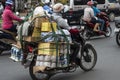 Vietnamese woman carries blue china on a scooter in the traffic of Ho Chi Minh City, Vietnam