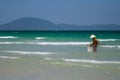 A Vietnamese woman is collecting sea shells on the shore in Nha Trang, Vietnam Royalty Free Stock Photo