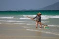 A Vietnamese woman is collecting sea shells on the shore in Nha Trang, Vietnam Royalty Free Stock Photo