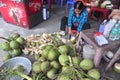 A Vietnamese woman is cutting coconut for travellers on a treet vendor