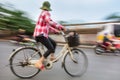 Vietnamese woman cycling on a bicycle on the streets of Vietnam, South East Asia