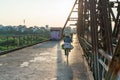 Vietnamese woman cylcing on bike on Long Bien old metal bridge