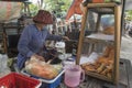 Vietnamese woman makes and sells snacks in a street of Ho Chi Minh City