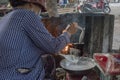 Vietnamese woman makes and sells snacks in a street of Ho Chi Minh City