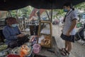Vietnamese woman makes and sells snacks to a student in a street of Ho Chi Minh City