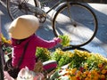 Vietnamese Woman with Non La and Pink Jacket Selling Chrysanthemums in an Outdoor Market